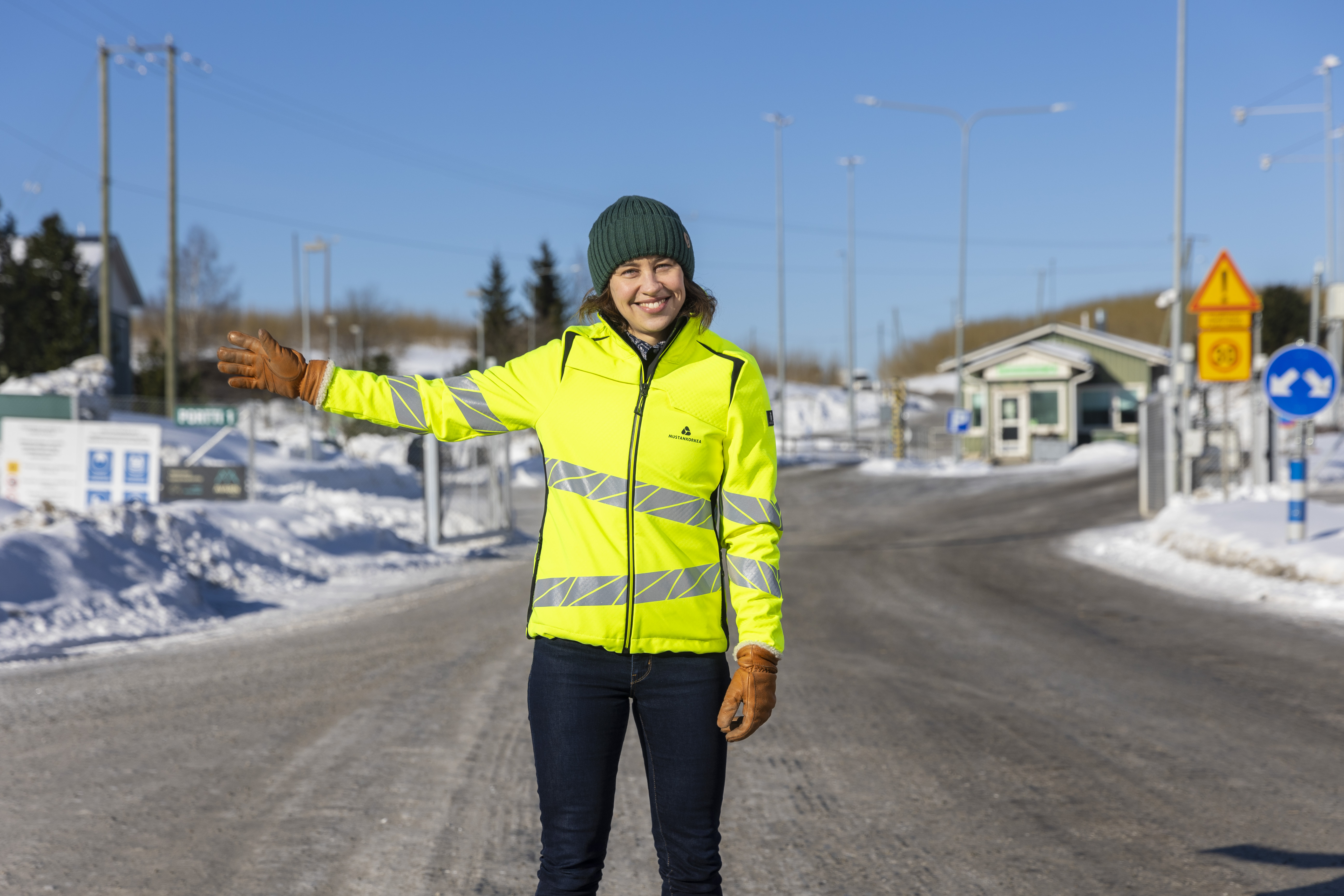 Huomiovaatteissa oleva nainen viitelöi kääntymään vasemmalle.