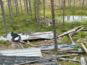 Metsään on jätetty epämääräistä puuta, vanhoja renkaita ja muovia.